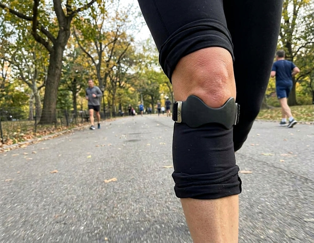 Sangle rotulienne Flexo noire portée sur un legging pendant un footing